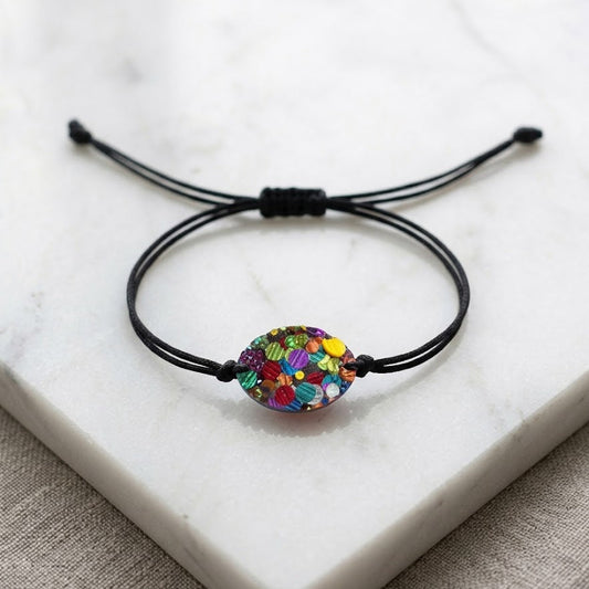 Bracelet with a colorful bead on a white marble surface