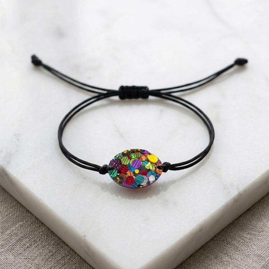 Bracelet with a colorful bead on a white marble surface