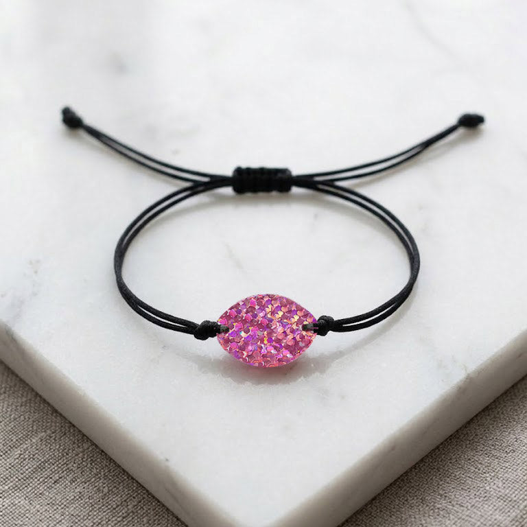 Black cord bracelet with a pink gemstone